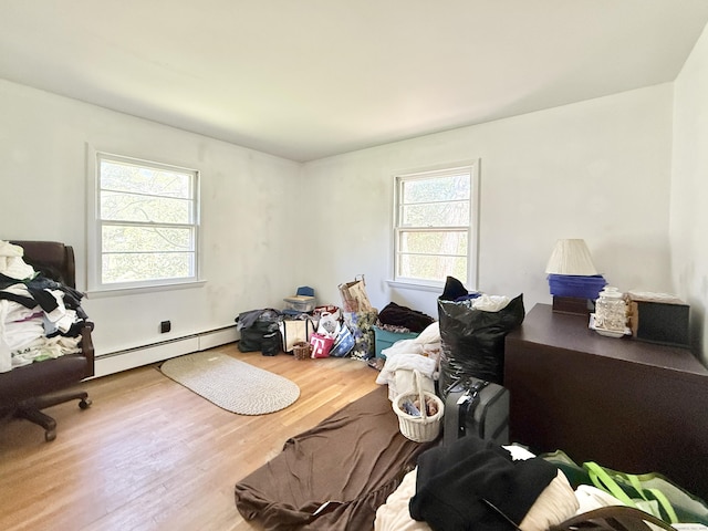 bedroom with baseboard heating and wood finished floors