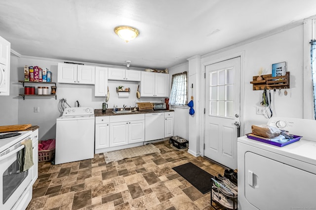 kitchen with white appliances, white cabinetry, stone finish floor, and a sink
