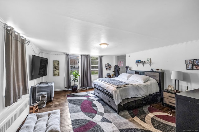 bedroom featuring radiator and wood finished floors