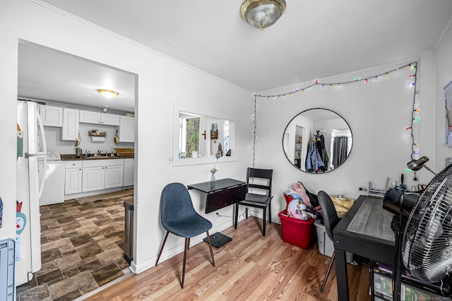 office area featuring baseboards, ornamental molding, and a sink