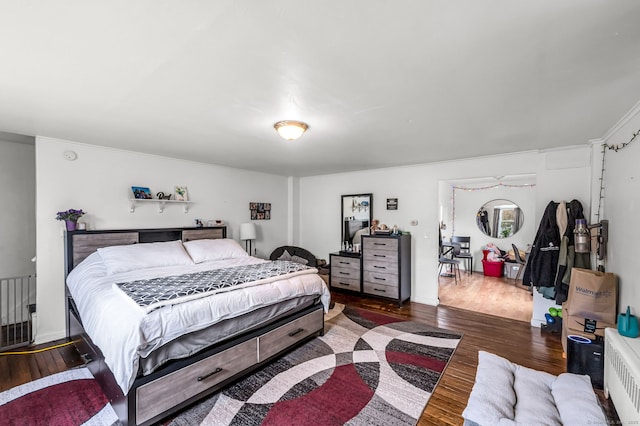 bedroom with crown molding and wood finished floors