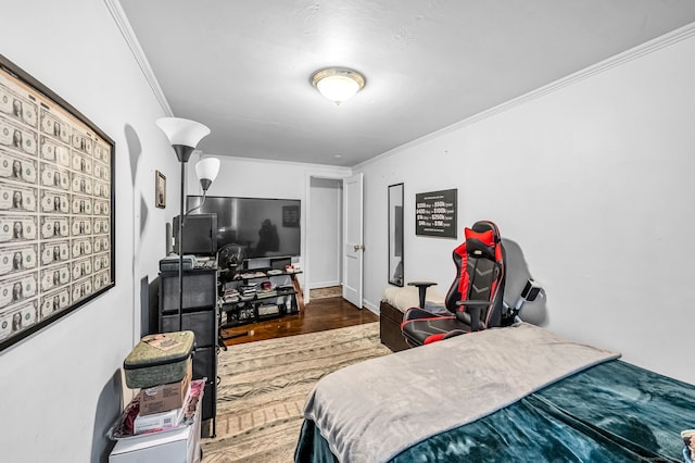bedroom with ornamental molding and wood finished floors