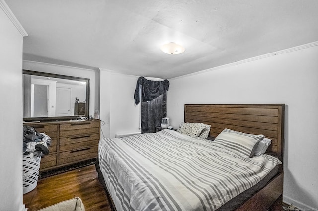 bedroom with ornamental molding and wood finished floors