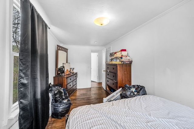 bedroom with ornamental molding and dark wood-style flooring