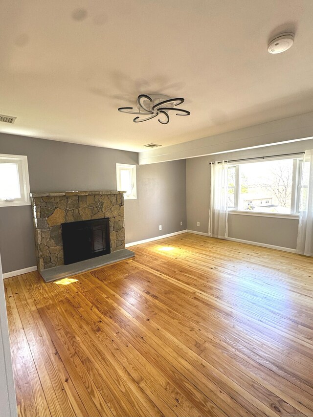 6 Fulton Dr, New Fairfield, CT 06812 - unfurnished living room featuring visible vents, baseboards, wood finished floors, and a fireplace