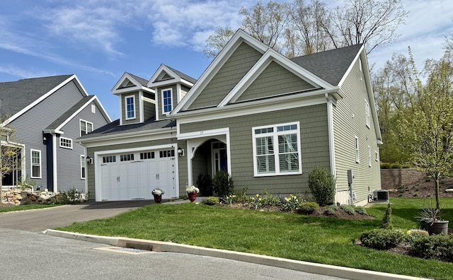 view of front facade with a garage, a front lawn, aphalt driveway, central AC, and roof with shingles