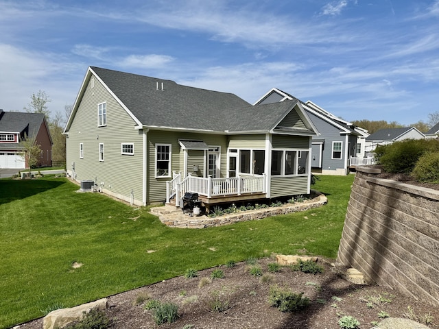 rear view of house with roof with shingles, central air condition unit, a yard, and a deck