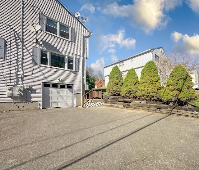 139 Downes St Unit 139, Waterbury, CT 06704 - view of property exterior featuring an attached garage and driveway