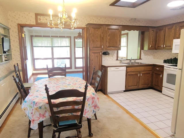 kitchen featuring a sink, baseboard heating, white appliances, a chandelier, and wallpapered walls