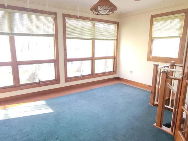 spare room with baseboards and carpet