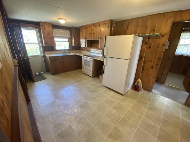 318 Billow Rd, Old Lyme, CT 06371 - kitchen with white appliances, wood walls, a sink, and light countertops