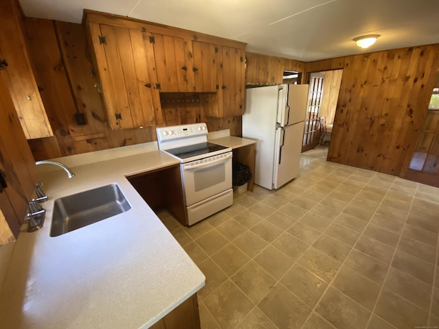 318 Billow Rd, Old Lyme, CT 06371 - kitchen featuring brown cabinets, a sink, white appliances, light countertops, and wood walls