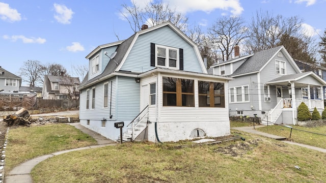 colonial inspired home featuring a gambrel roof, stairway, a front yard, and a chimney