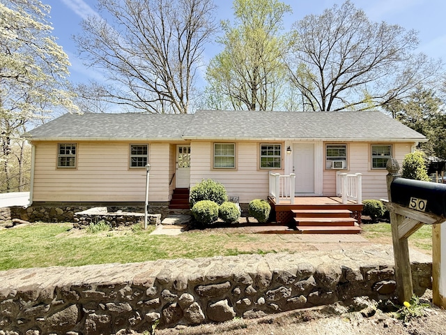 single story home featuring a deck and roof with shingles