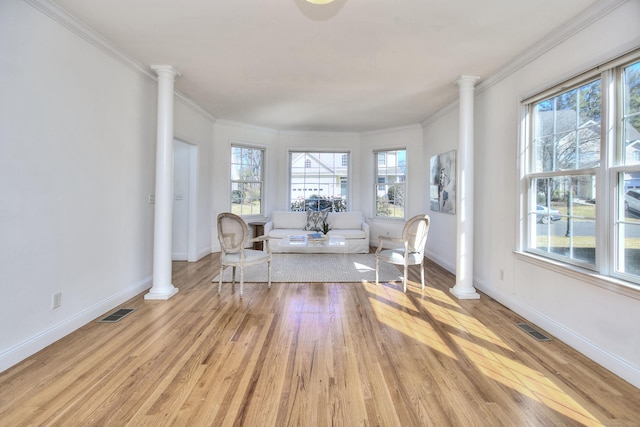 living area featuring visible vents, light wood-style flooring, ornate columns, and baseboards