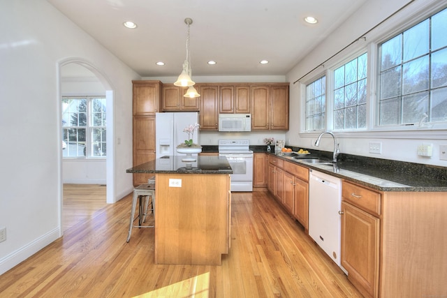 kitchen featuring recessed lighting, a sink, a kitchen island, and white appliances