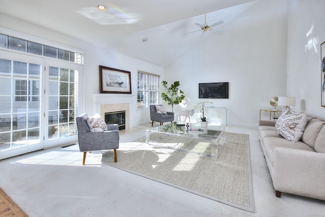 living room with a ceiling fan, high vaulted ceiling, baseboards, carpet floors, and a premium fireplace