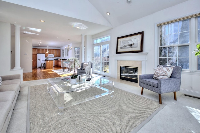 living area with visible vents, a tiled fireplace, ornate columns, lofted ceiling, and recessed lighting