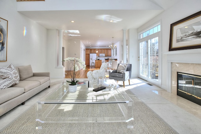 living area featuring decorative columns, visible vents, a fireplace, baseboards, and recessed lighting