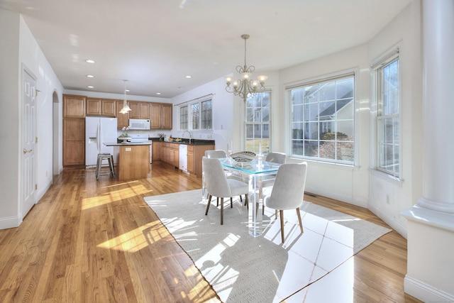 dining room with baseboards, a healthy amount of sunlight, and light wood-style flooring