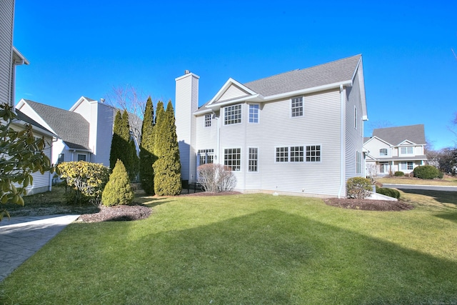 back of property with a lawn and a chimney