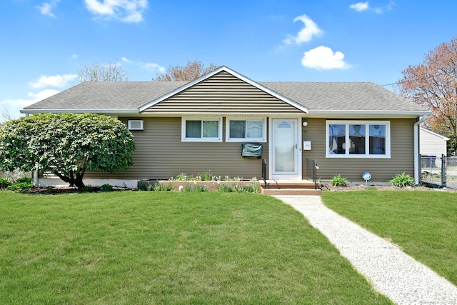 view of front of house with fence, a shingled roof, and a front lawn