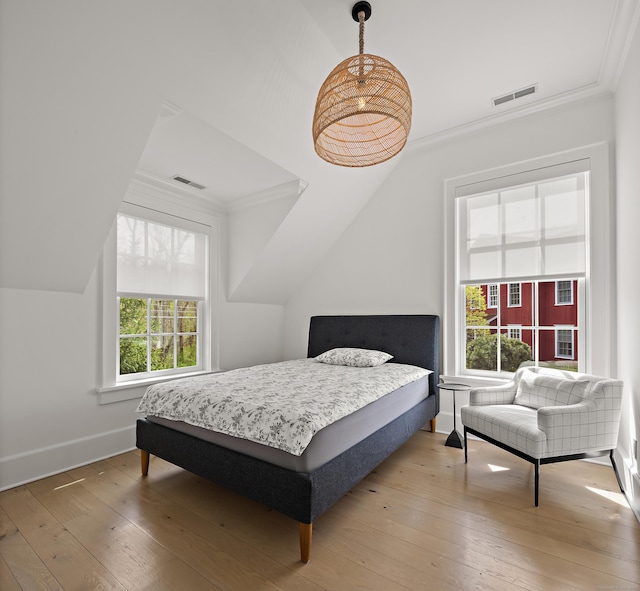 bedroom featuring visible vents, wood-type flooring, and crown molding