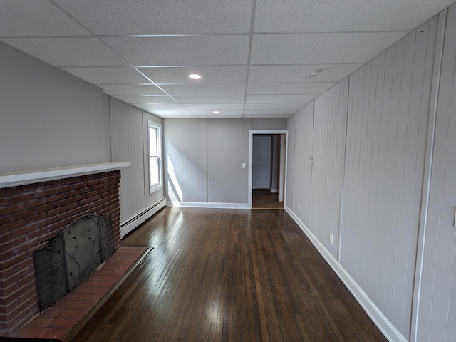327 Center St, West Haven, CT 06516 - unfurnished living room featuring recessed lighting, baseboards, a drop ceiling, a baseboard heating unit, and hardwood / wood-style flooring