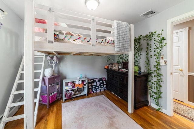 bedroom featuring visible vents and wood finished floors