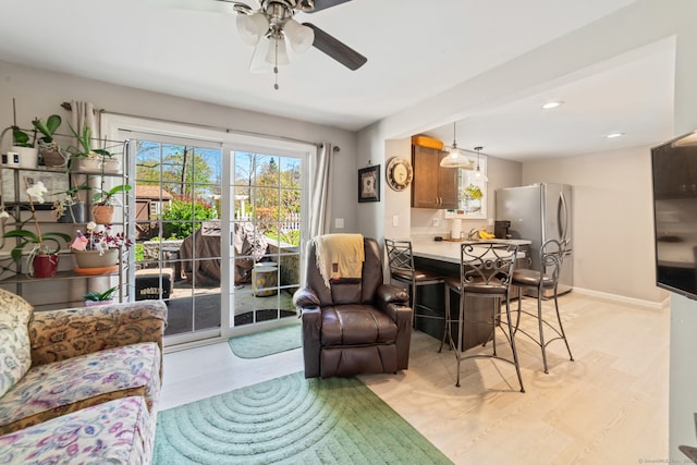 living room with light wood-style floors, baseboards, a ceiling fan, and recessed lighting