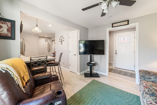 living area featuring ceiling fan, visible vents, baseboards, light wood-style floors, and recessed lighting