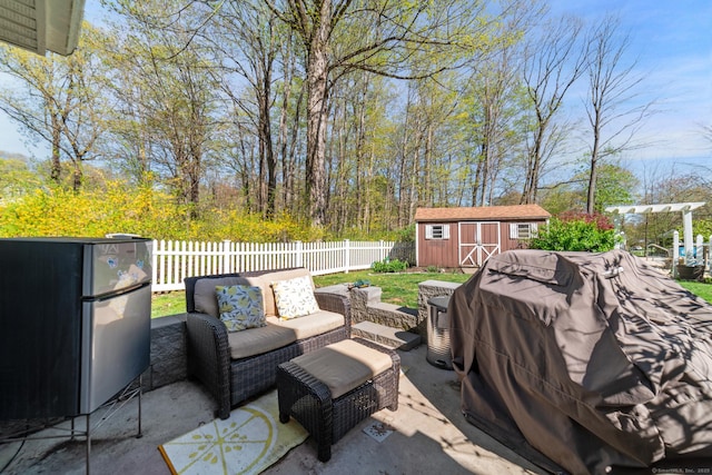 view of patio featuring a storage shed, fence, an outdoor structure, and an outdoor hangout area