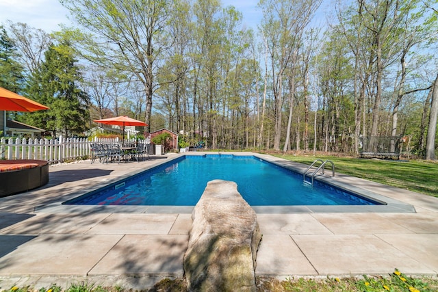 outdoor pool featuring fence, a patio, and a diving board