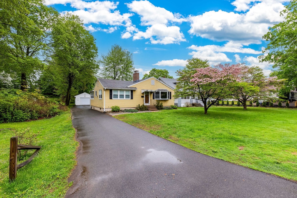 147 E Robbins Ave, Newington, CT 06111 - bungalow-style home featuring a chimney, a front yard, an outdoor structure, and a detached garage