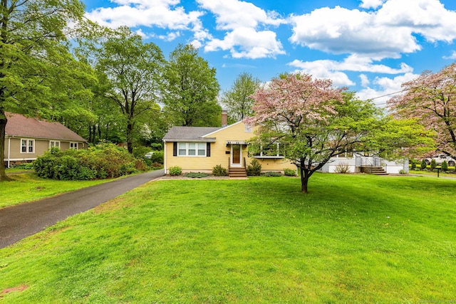 view of front of property with a front lawn, a chimney, and entry steps