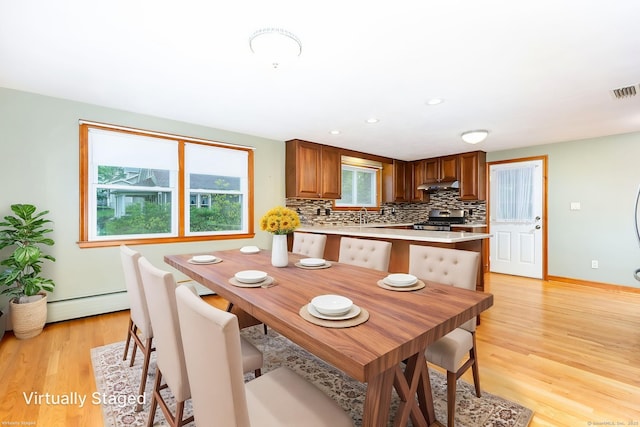 dining room with light wood finished floors, visible vents, baseboards, a baseboard radiator, and recessed lighting