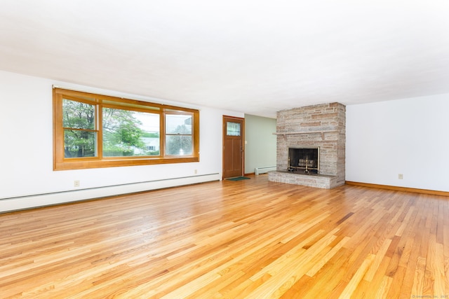 unfurnished living room featuring baseboards, wood finished floors, a baseboard radiator, and a fireplace
