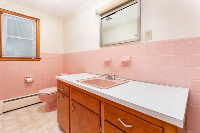 bathroom with tile walls, toilet, vanity, a baseboard radiator, and wainscoting