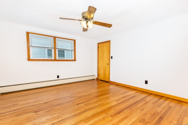 spare room with baseboards, a baseboard radiator, light wood-type flooring, and a ceiling fan
