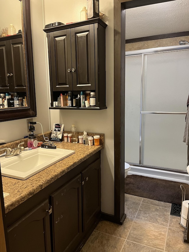 bathroom with a shower stall, vanity, and toilet