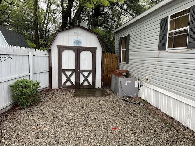 view of shed with central AC and fence