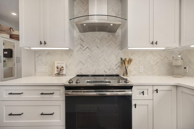 kitchen with light countertops, electric range, backsplash, and exhaust hood