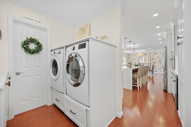 clothes washing area with laundry area, recessed lighting, wood finished floors, and washing machine and clothes dryer