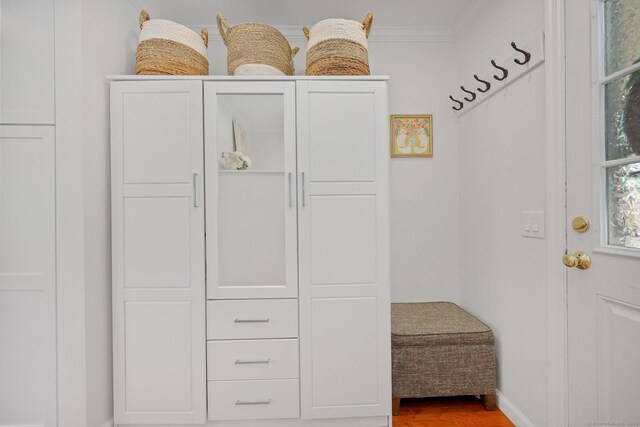 mudroom with baseboards, ornamental molding, and wood finished floors
