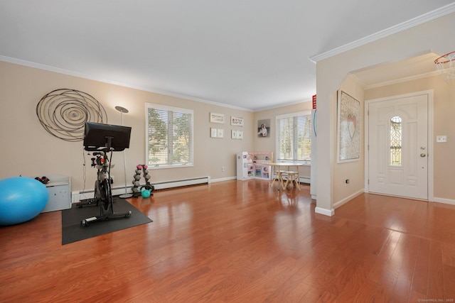 exercise room with baseboards, ornamental molding, a baseboard radiator, and wood finished floors