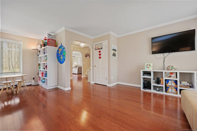 living area featuring arched walkways, wood finished floors, baseboards, a baseboard heating unit, and ornamental molding
