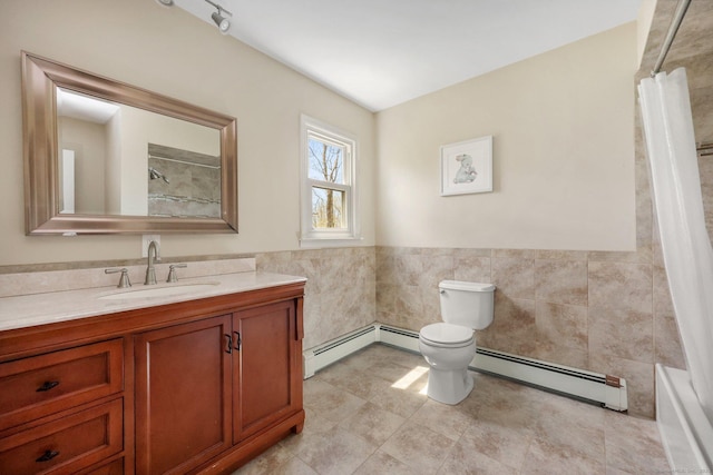 full bathroom featuring vanity, a baseboard radiator, toilet, and tile walls