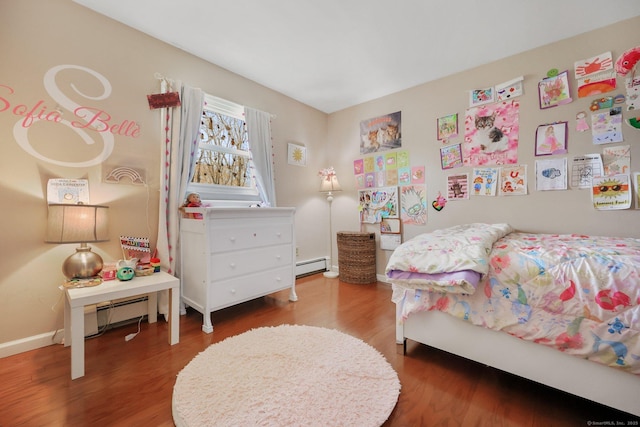 bedroom with baseboards, a baseboard radiator, and wood finished floors