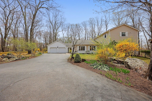 traditional-style home featuring a garage and aphalt driveway
