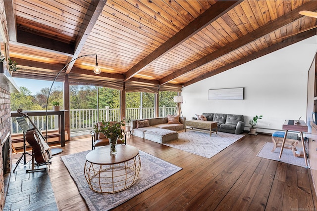 living room with lofted ceiling with beams, wood ceiling, a healthy amount of sunlight, and hardwood / wood-style floors